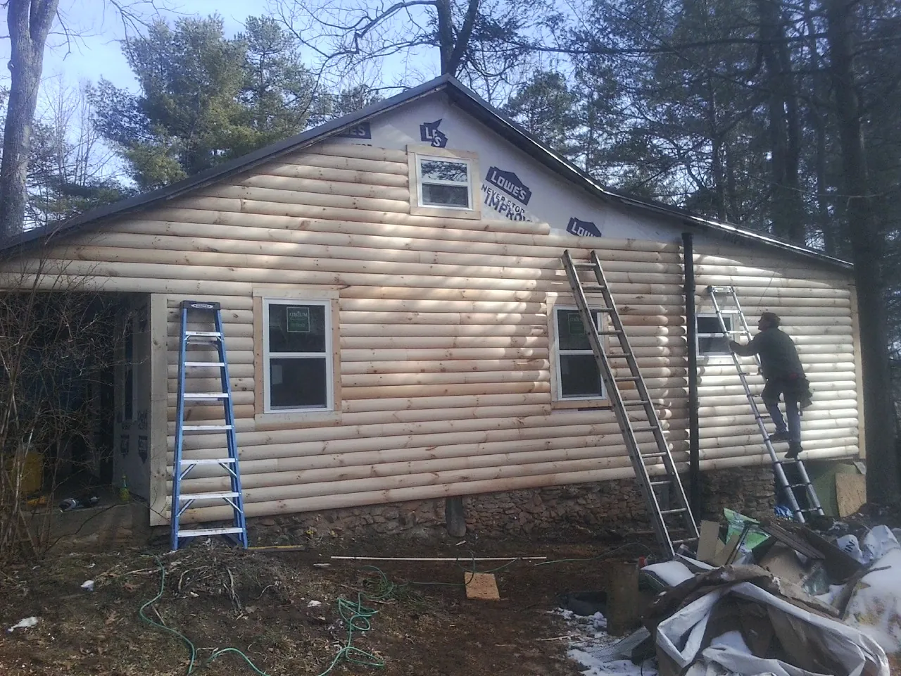 Ladders set against fresh log siding during an exterior remodel in Riverside